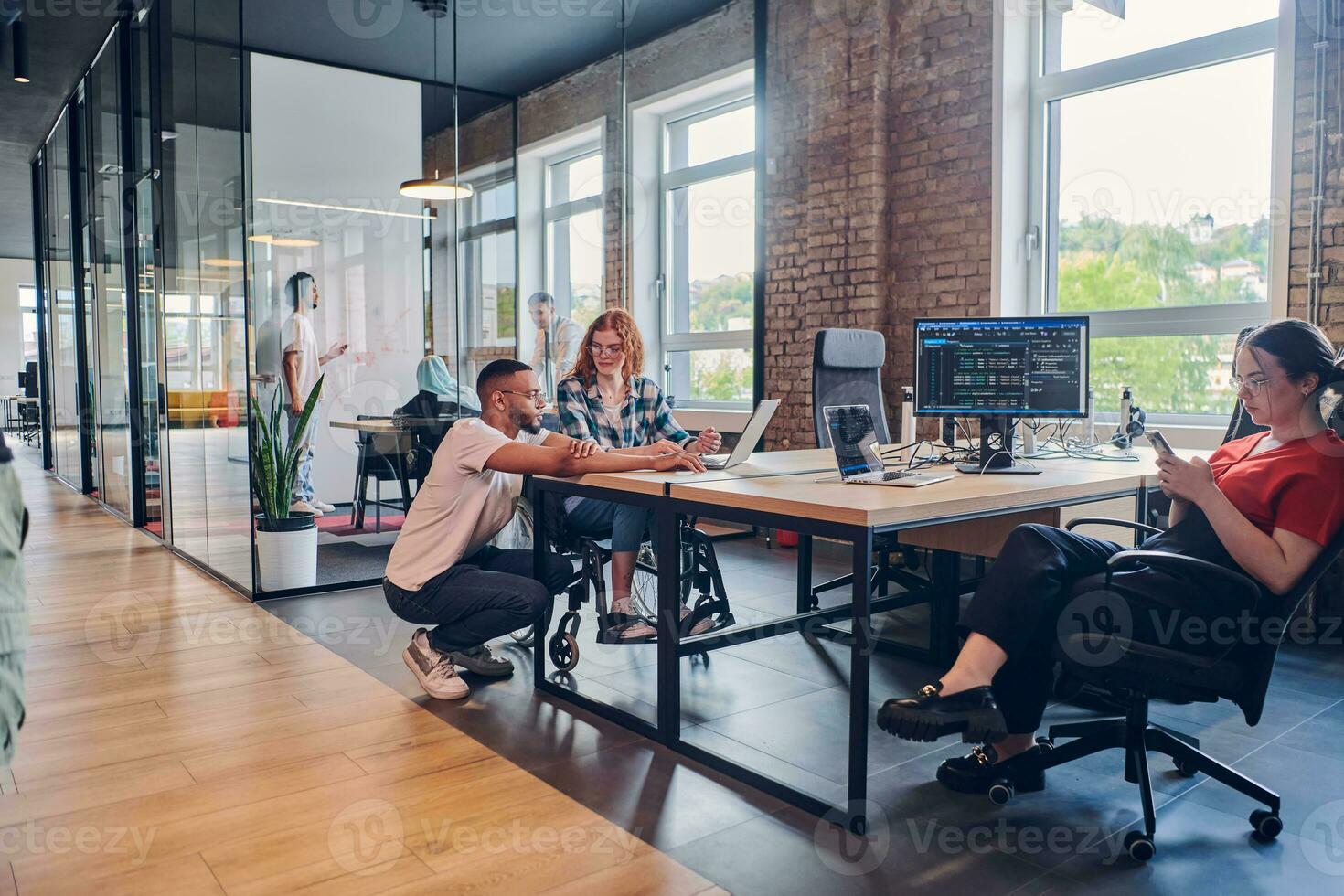 A diverse group of business professionals collaborates in a modern startup coworking center, utilizing a mix of paper-based and technological tools such as mobile phones and computers to collectively tackle a range of business challenges. photo