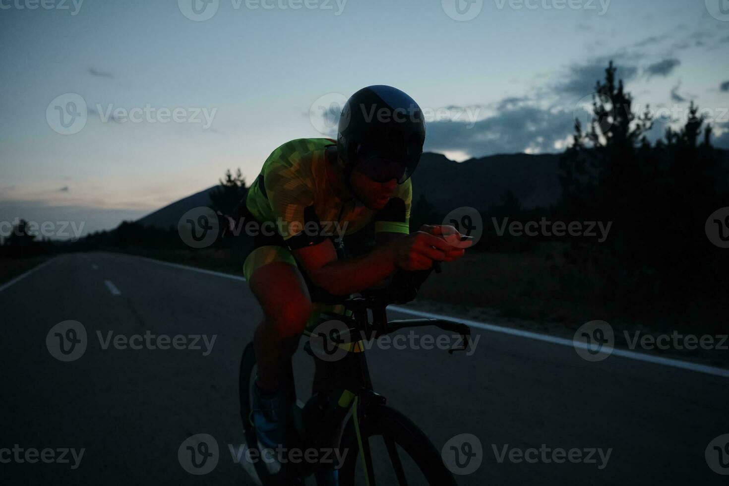 atleta de triatlón montando bicicleta por la noche foto