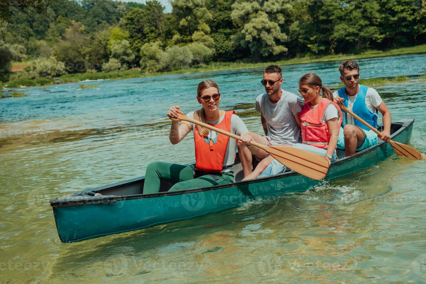Group adventurous explorer friends are canoeing in a wild river photo