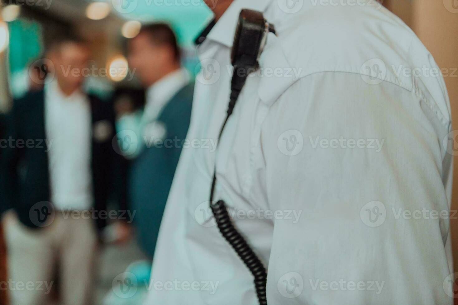 A close-up photo of a guard holding a communication device