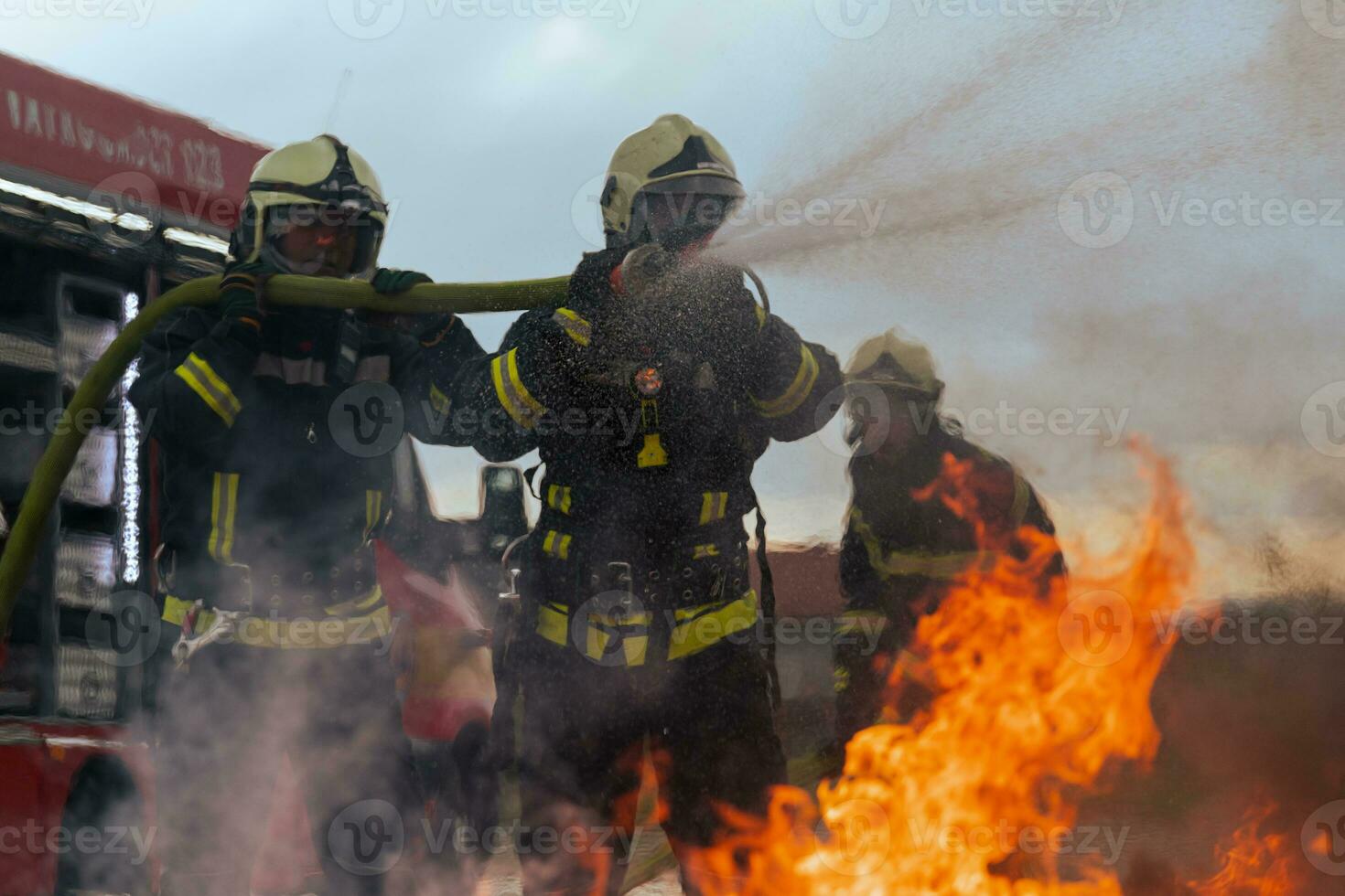 Firefighters fight the fire flame to control fire not to spreading out. Firefighter industrial and public safety concept. Traffic or car accident rescue and help action. photo