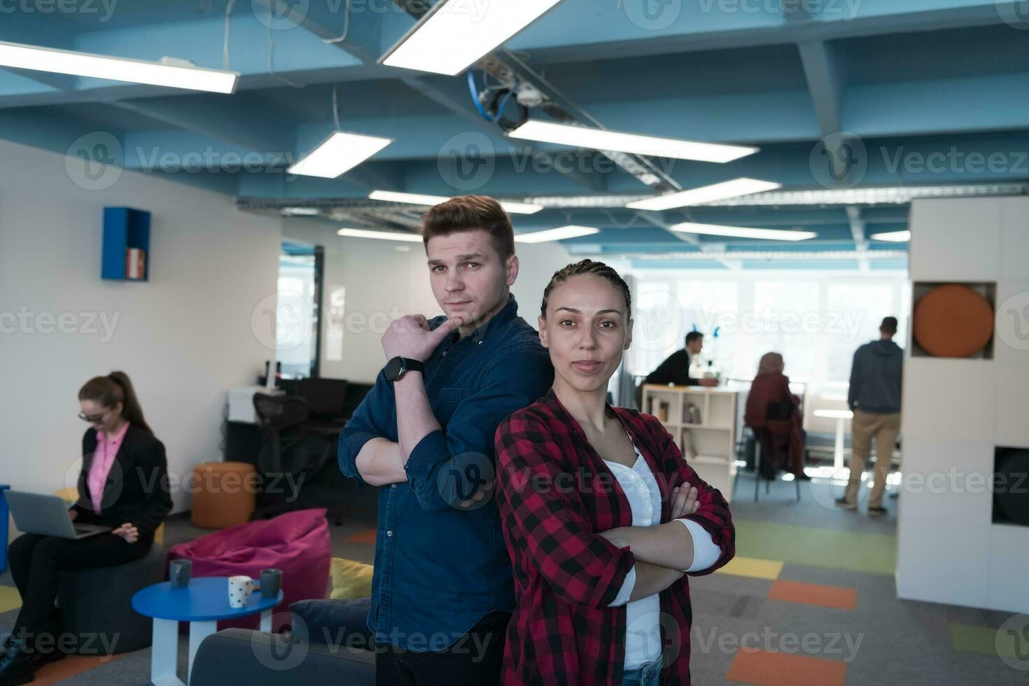 Portrait of a successful creative businessman and businesswoman looking at camera and smiling. Diverse business people standing together at startup. photo