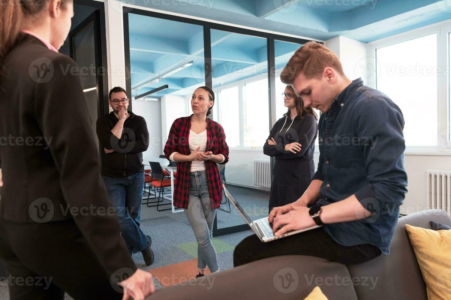 Multiethnic startup business team on meeting in a creative modern bright open space coworking office. Brainstorming, an assistant working on laptop. Group of coworkers woman leader. photo