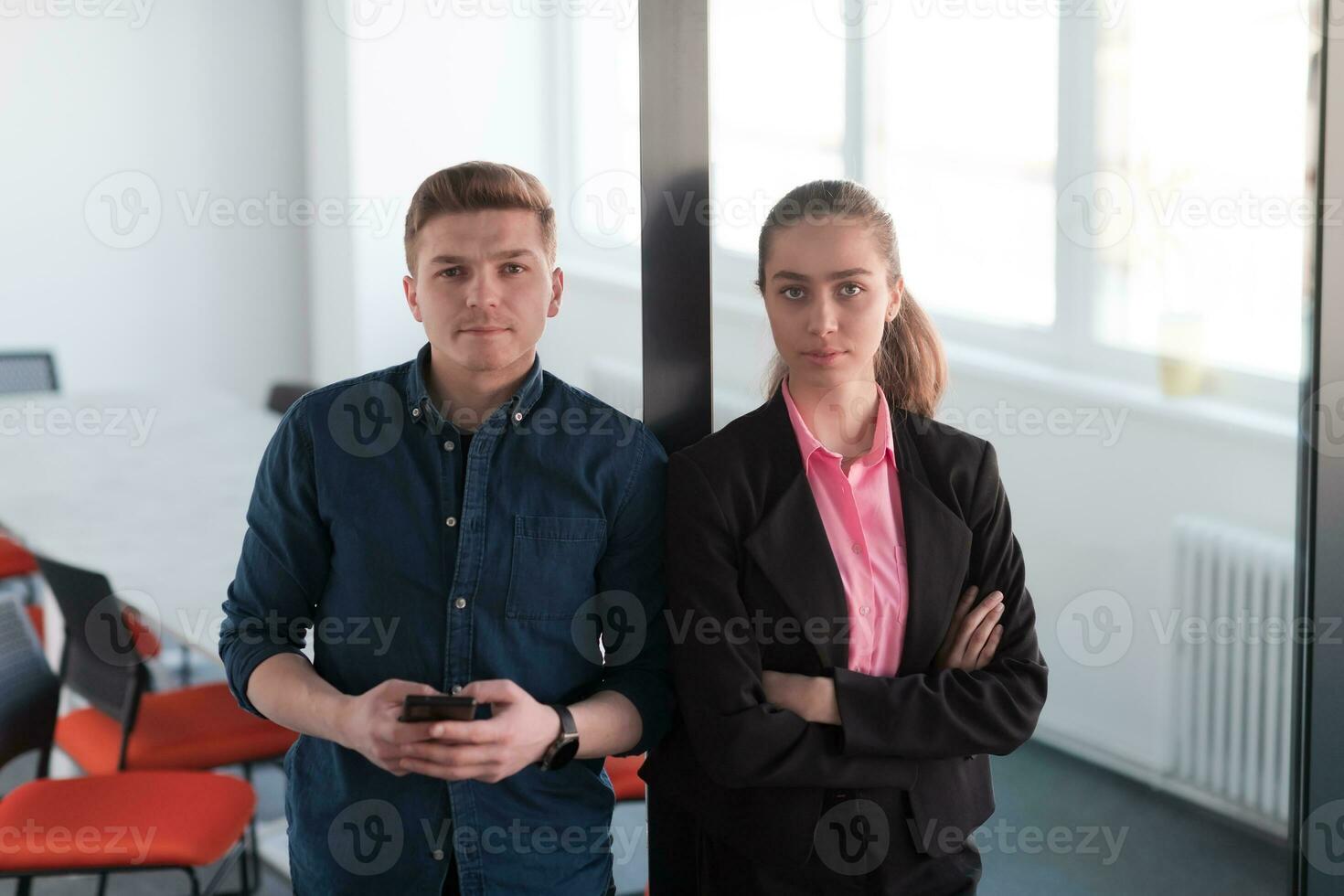 Portrait of a successful creative businessman and businesswoman looking at camera and smiling. Diverse business people standing together at startup. photo