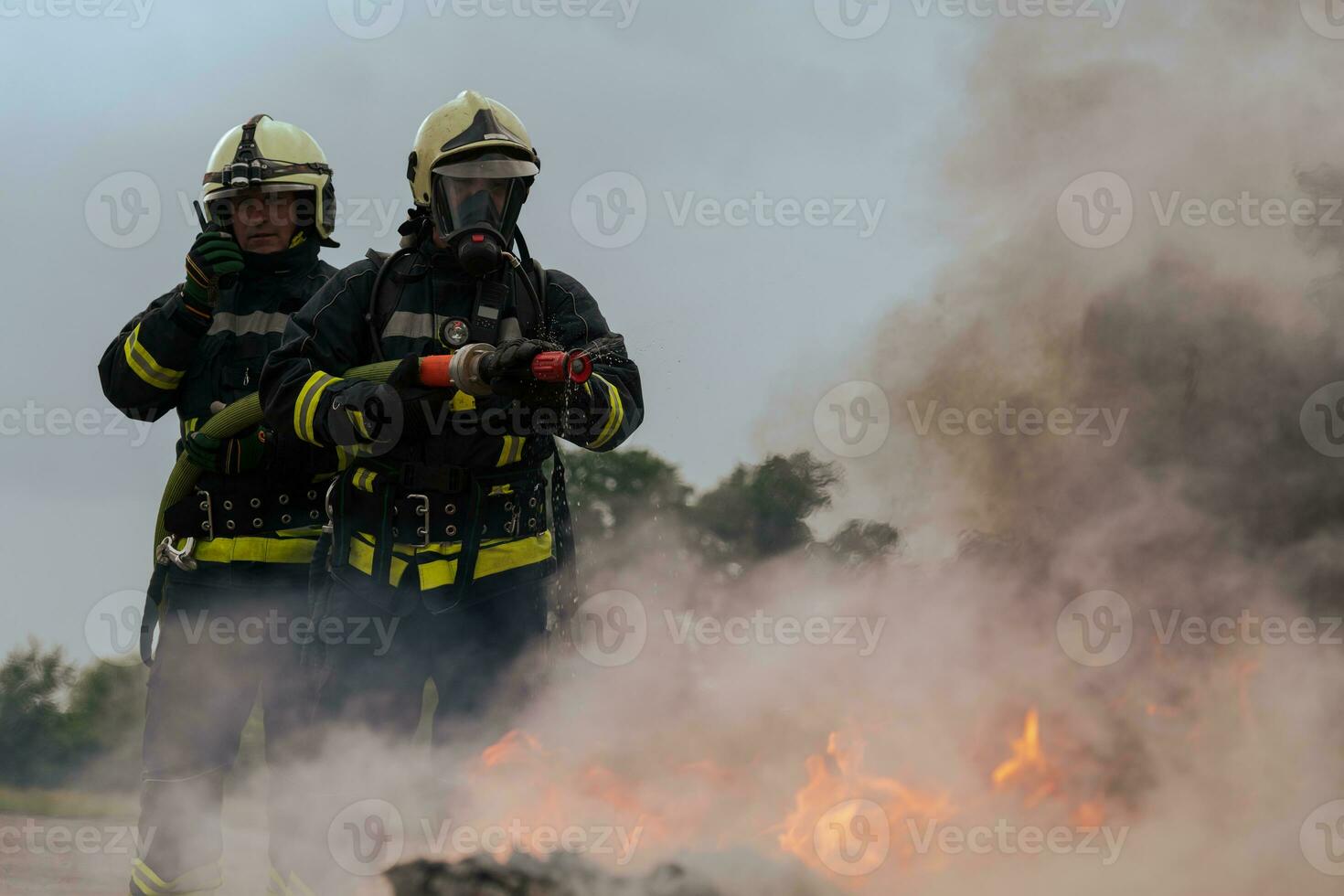 Firefighters fight the fire flame to control fire not to spreading out. Firefighter industrial and public safety concept. Traffic or car accident rescue and help action. photo