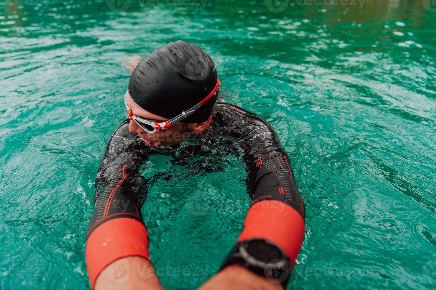 A triathlete in a professional swimming suit trains on the river while preparing for Olympic swimming photo