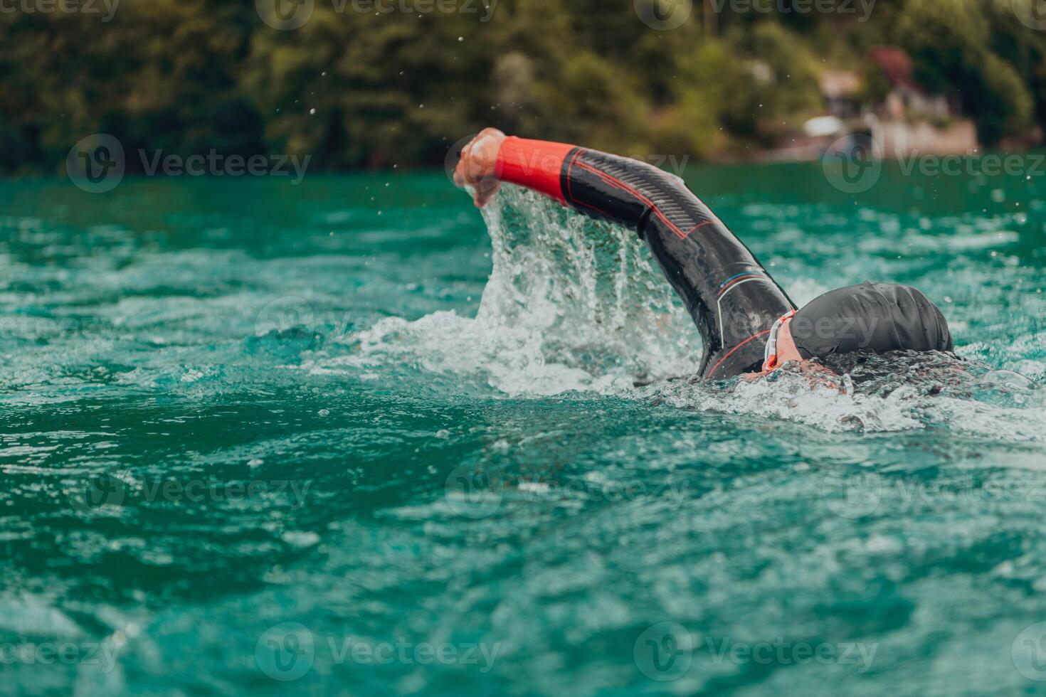 A triathlete in a professional swimming suit trains on the river while preparing for Olympic swimming photo