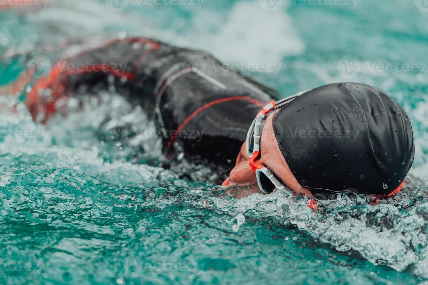 A triathlete in a professional swimming suit trains on the river while preparing for Olympic swimming photo