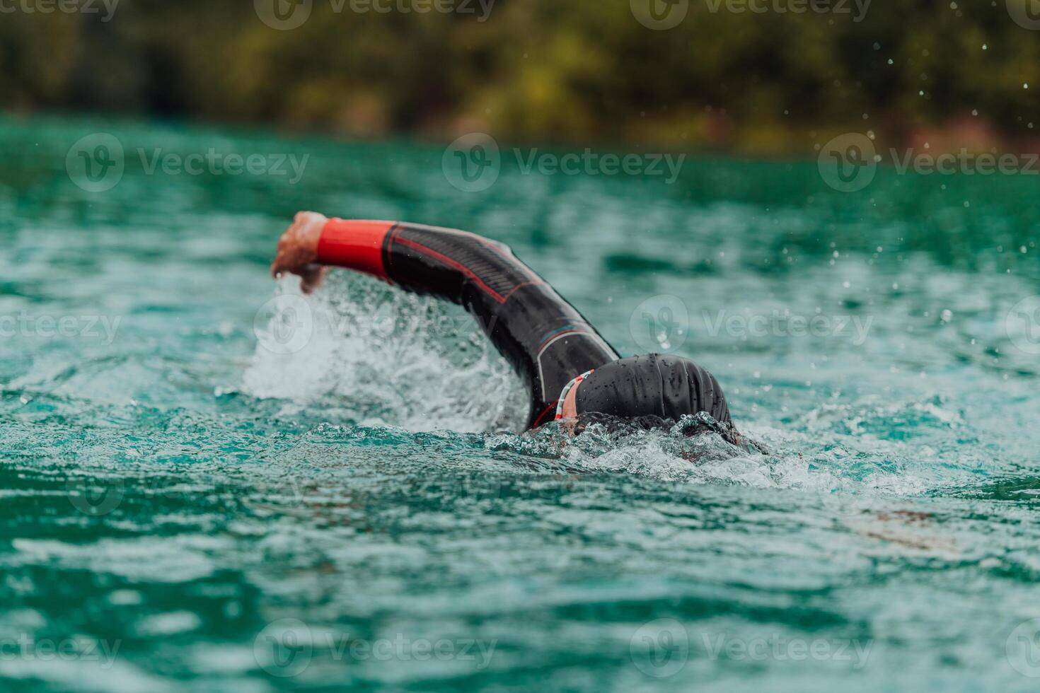 A triathlete in a professional swimming suit trains on the river while preparing for Olympic swimming photo