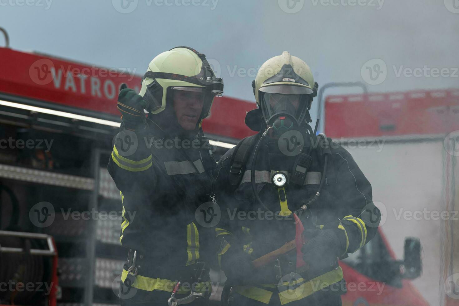 Firefighters using water fog type fire extinguisher to fighting with the fire flame to control fire not to spreading out. Firefighter industrial and public safety concept. photo