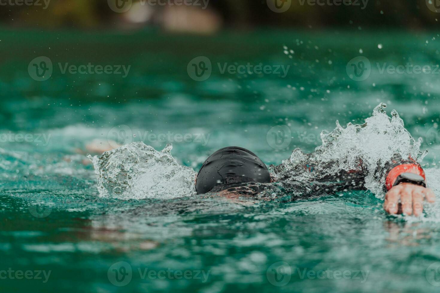 A triathlete in a professional swimming suit trains on the river while preparing for Olympic swimming photo