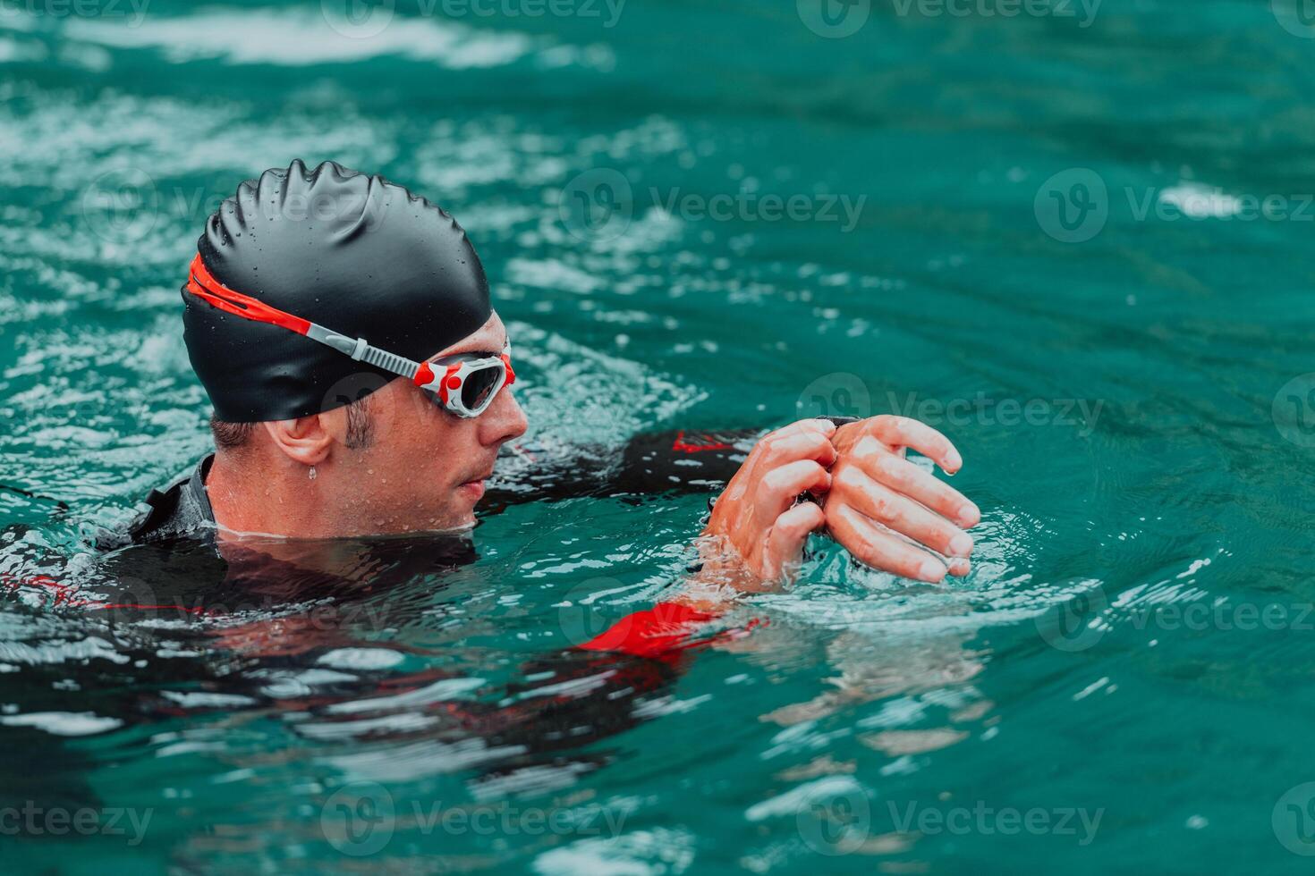 A triathlete in a professional swimming suit trains on the river while preparing for Olympic swimming photo