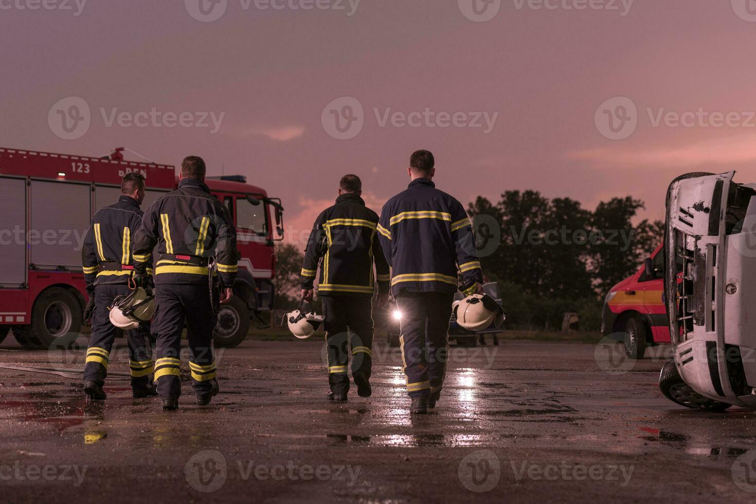 valiente bomberos equipo caminando a el cámara. en antecedentes paramédicos y bomberos rescate equipo lucha fuego en coche accidente, seguro y salvar pueblos vive concepto. foto