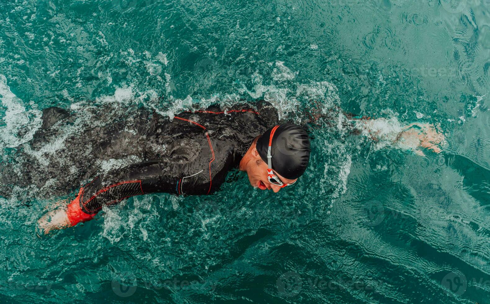 A triathlete in a professional swimming suit trains on the river while preparing for Olympic swimming photo