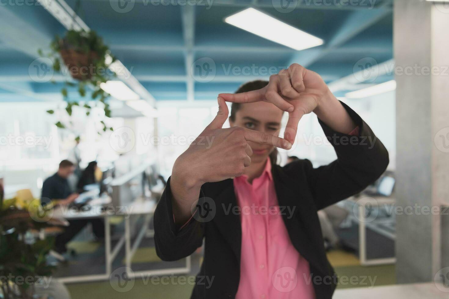Closeup of hands, Smiling Business Woman Making Frame Gesture with at modern bright coworking open space startup office. photo