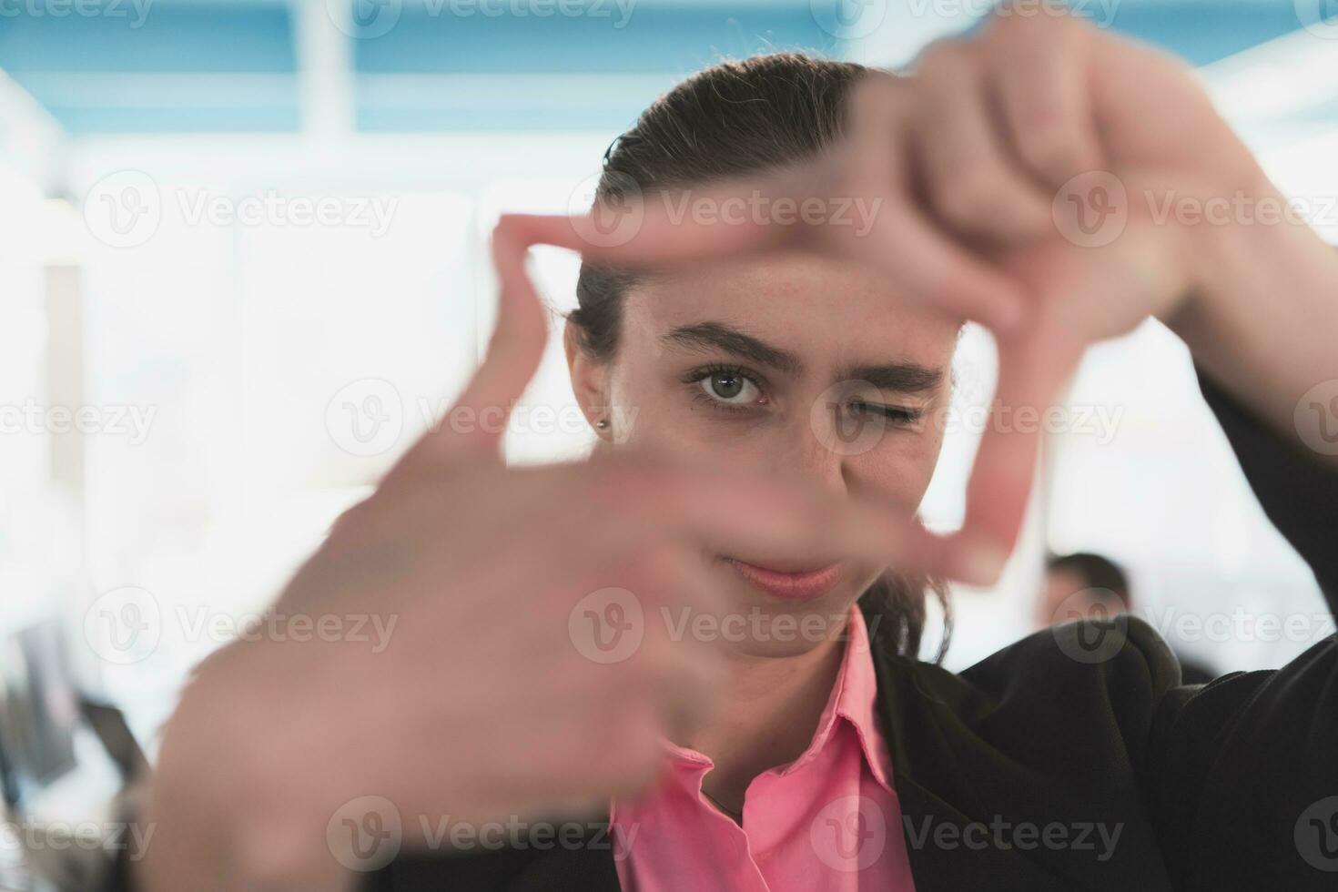 Closeup of hands, Smiling Business Woman Making Frame Gesture with at modern bright coworking open space startup office. photo