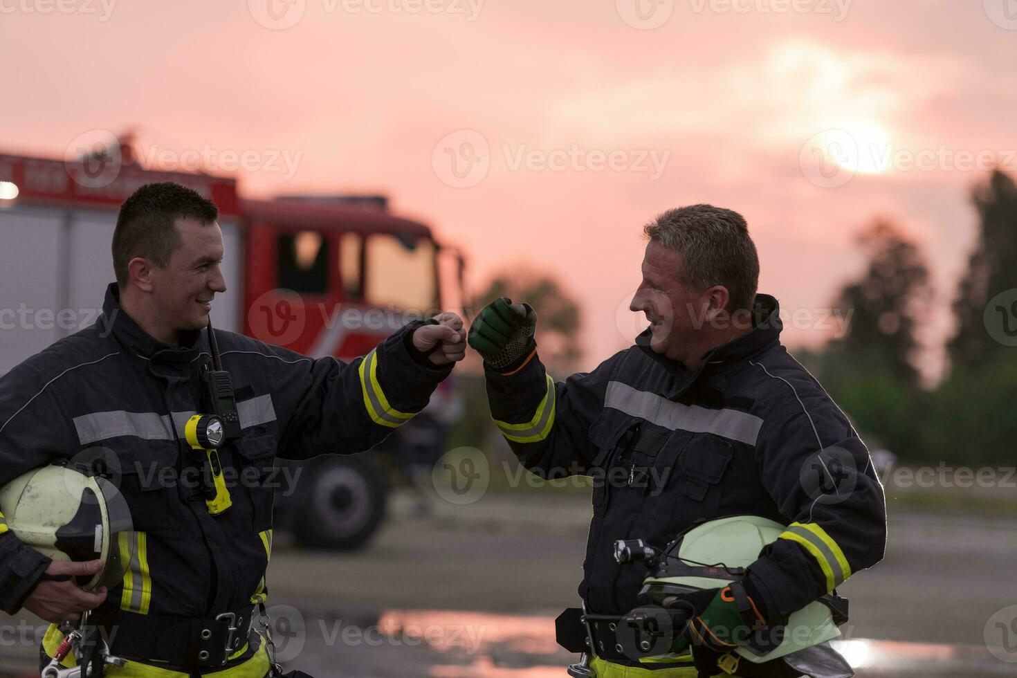 Fireman using walkie talkie at car traffic rescue action fire truck and fireman's team in background. photo