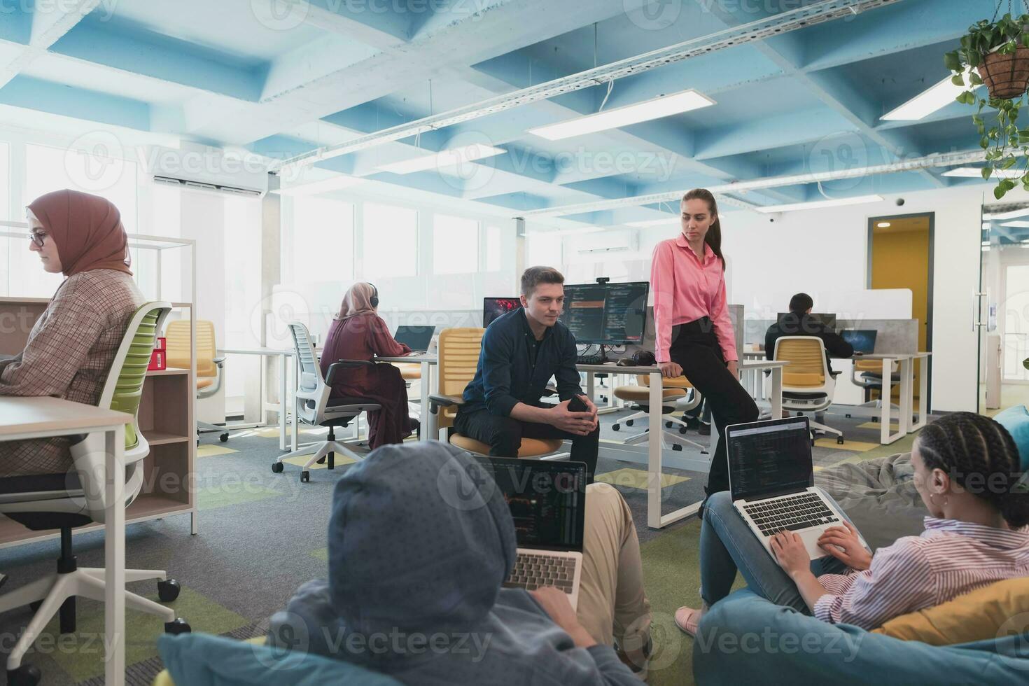 Collaborative process of multicultural skilled young business team during brainstorming meeting in office.Diverse group of young people dressed in formal wear cooperating on developing design project photo
