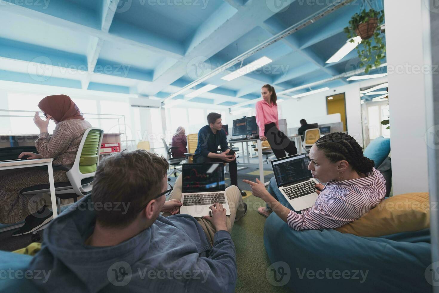 Collaborative process of multicultural skilled young business team during brainstorming meeting in office.Diverse group of young people dressed in formal wear cooperating on developing design project photo