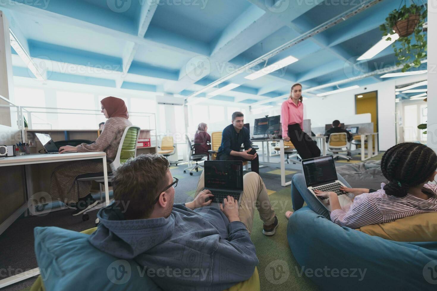 Collaborative process of multicultural skilled young business team during brainstorming meeting in office.Diverse group of young people dressed in formal wear cooperating on developing design project photo