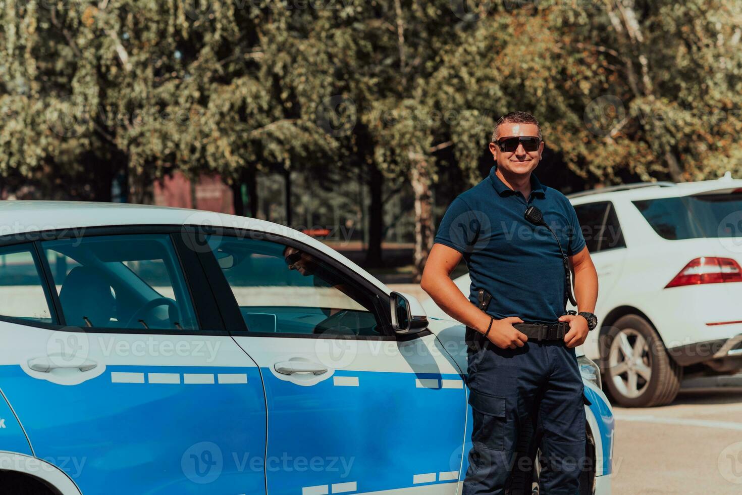 un Oficial de policía patrullas el ciudad. un policía oficial con Gafas de sol patrullando en el ciudad con un oficial policía coche foto