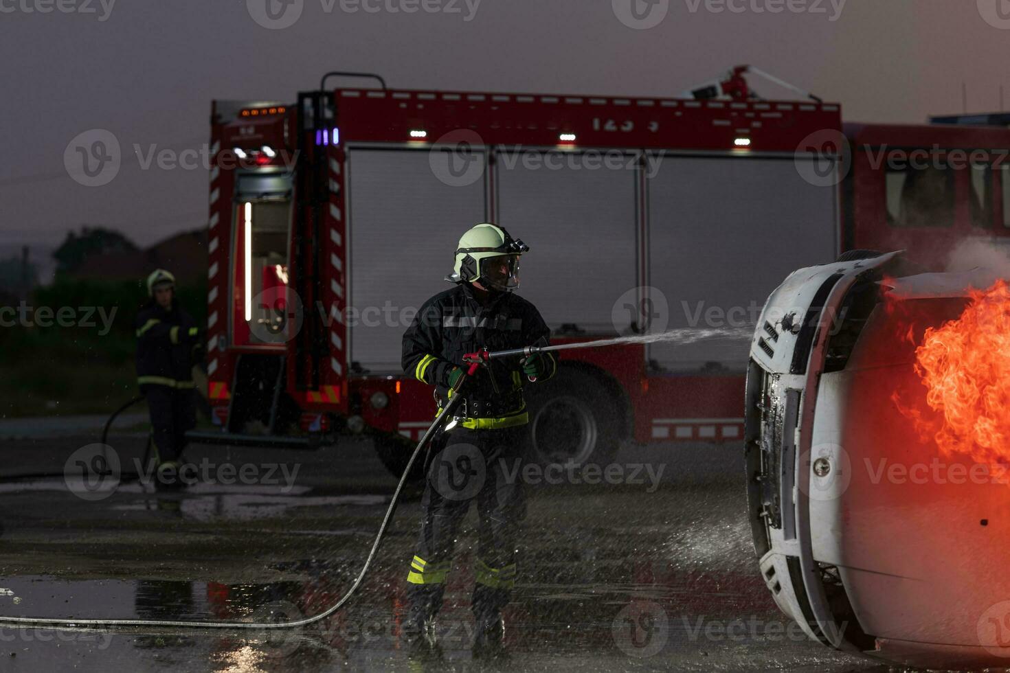 Firefighters fight the fire flame to control fire not to spreading out. Firefighter industrial and public safety concept. Traffic or car accident rescue and help action. photo