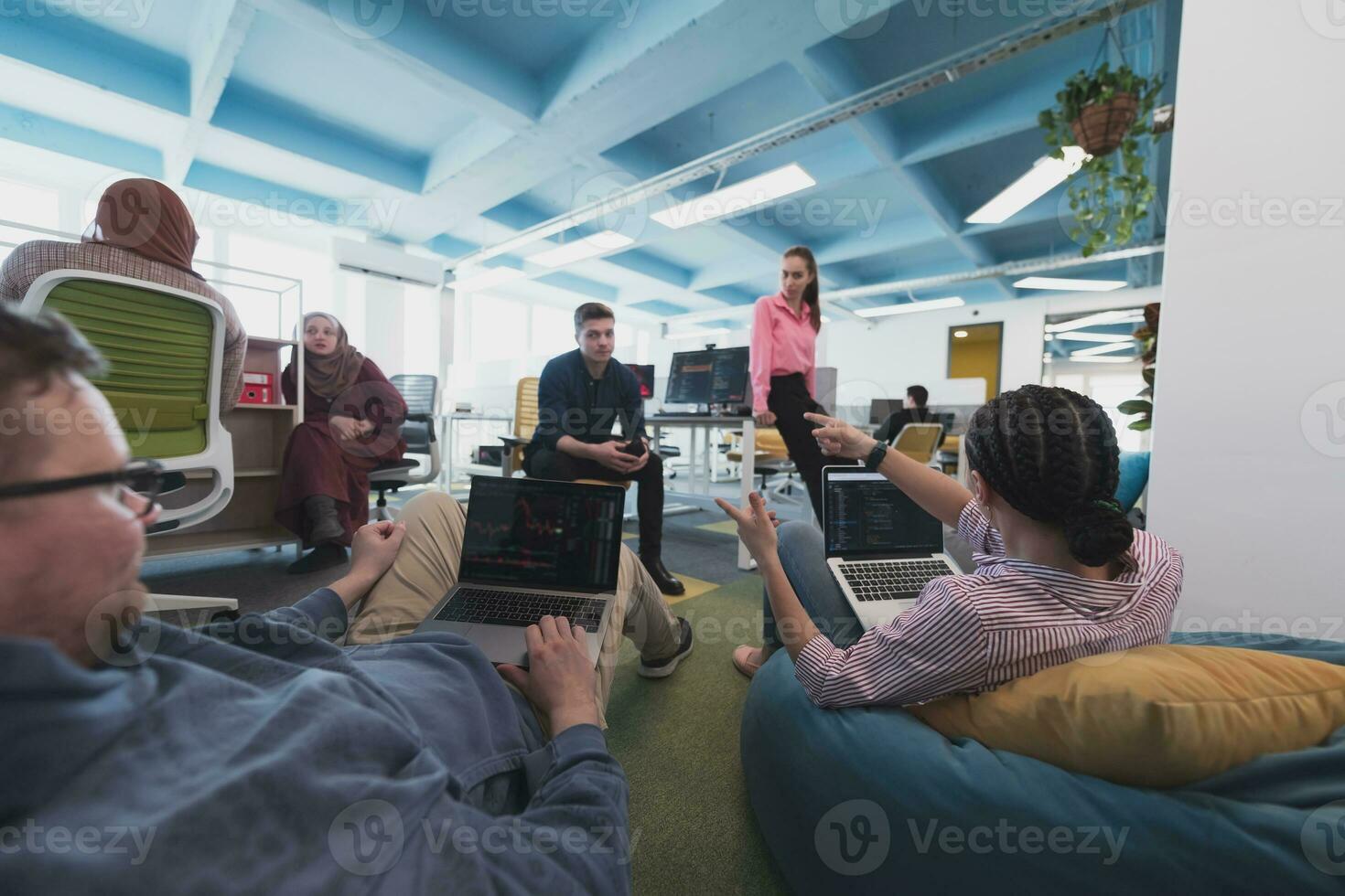 Collaborative process of multicultural skilled young business team during brainstorming meeting in office.Diverse group of young people dressed in formal wear cooperating on developing design project photo