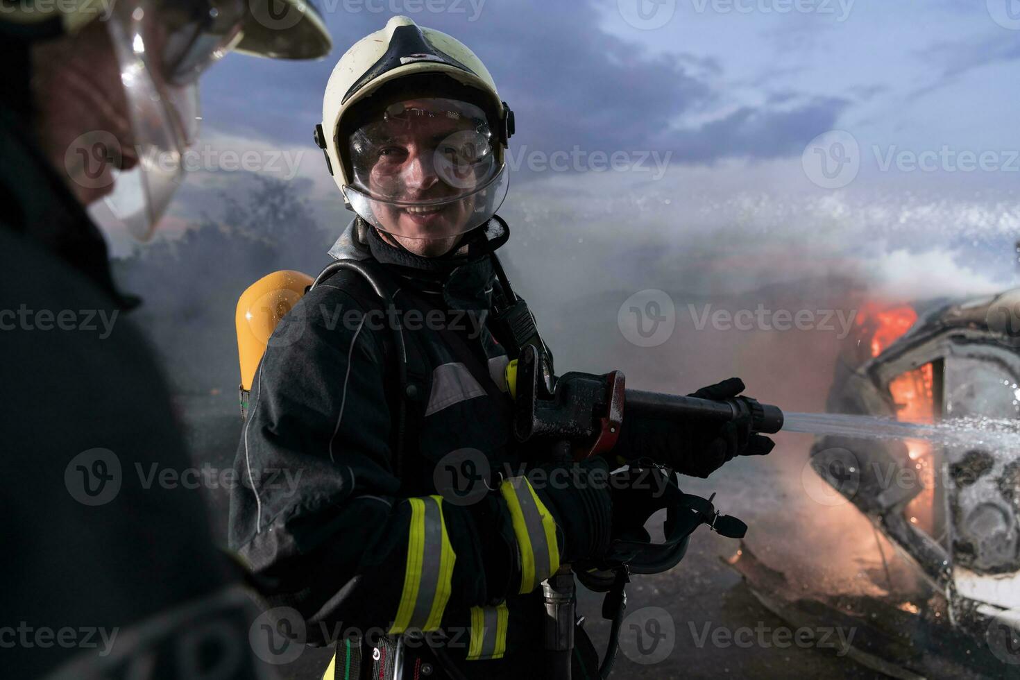 Firefighters fight the fire flame to control fire not to spreading out. Firefighter industrial and public safety concept. Traffic or car accident rescue and help action. photo