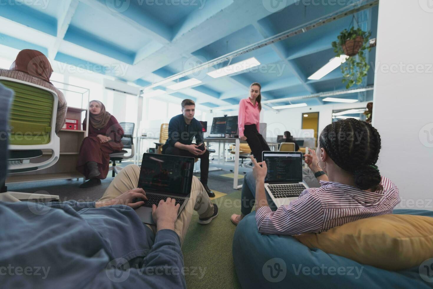 Collaborative process of multicultural skilled young business team during brainstorming meeting in office.Diverse group of young people dressed in formal wear cooperating on developing design project photo