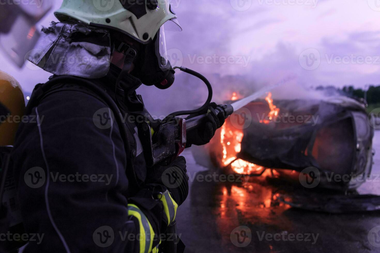 Firefighters fight the fire flame to control fire not to spreading out. Firefighter industrial and public safety concept. Traffic or car accident rescue and help action. photo