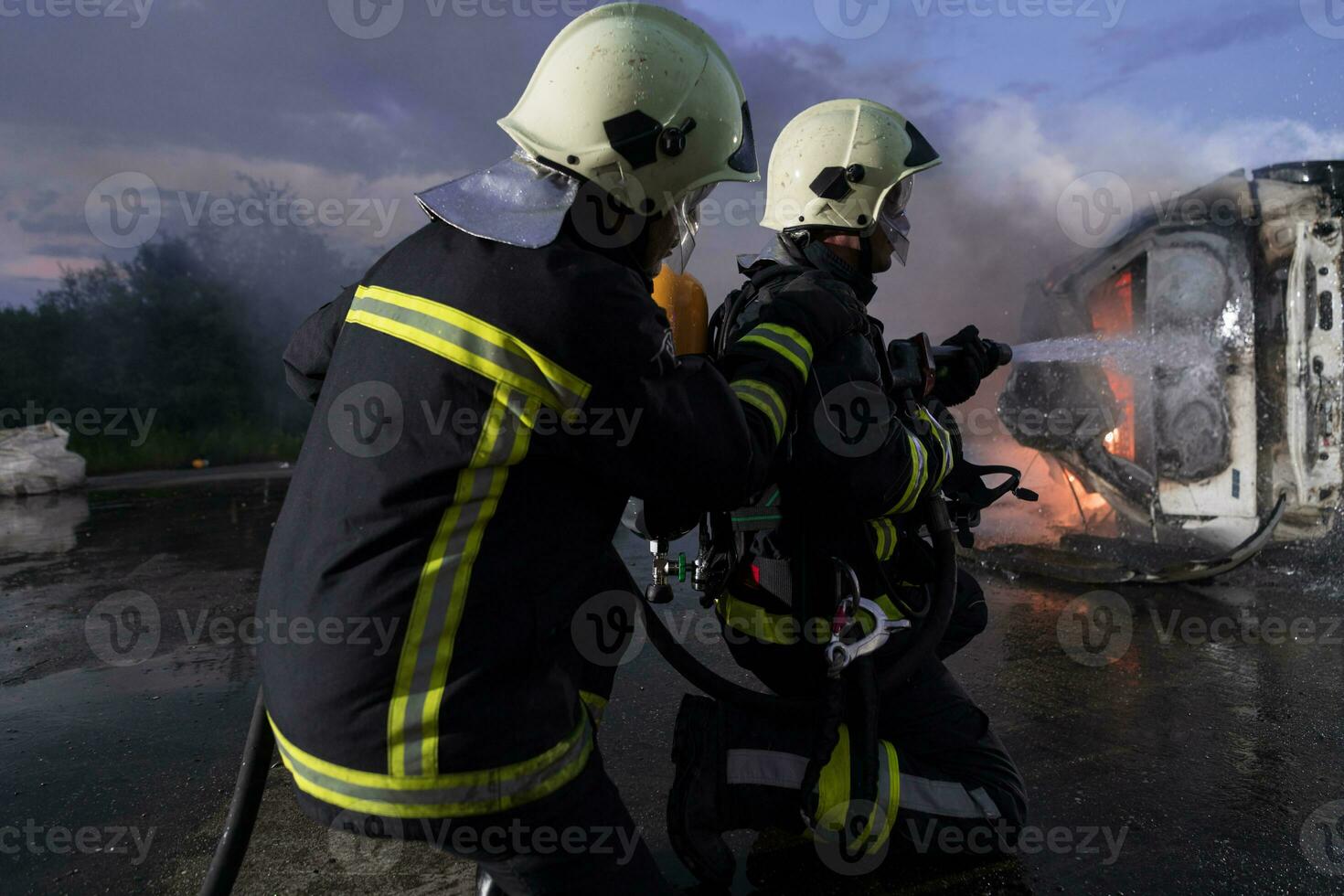 bomberos utilizando agua fuego extintor a luchando con el fuego fuego en coche accidente. bombero industrial y público la seguridad concepto rescate en noche. foto