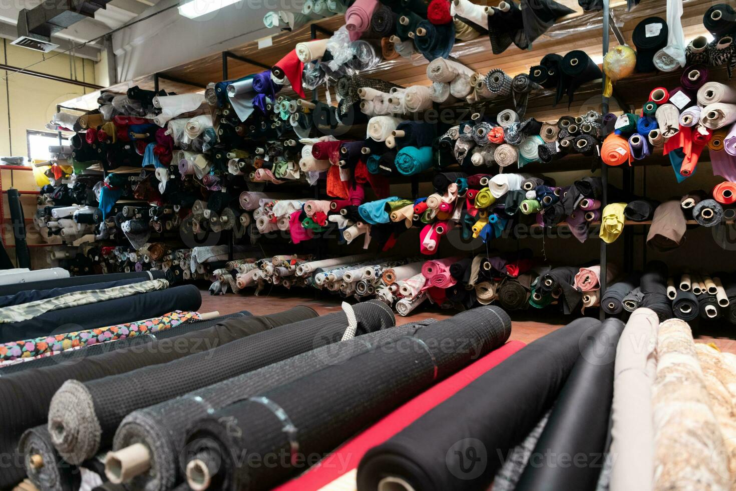 Interior of an industrial warehouse with fabric rolls samples. Small business textile colorful warehouse. photo