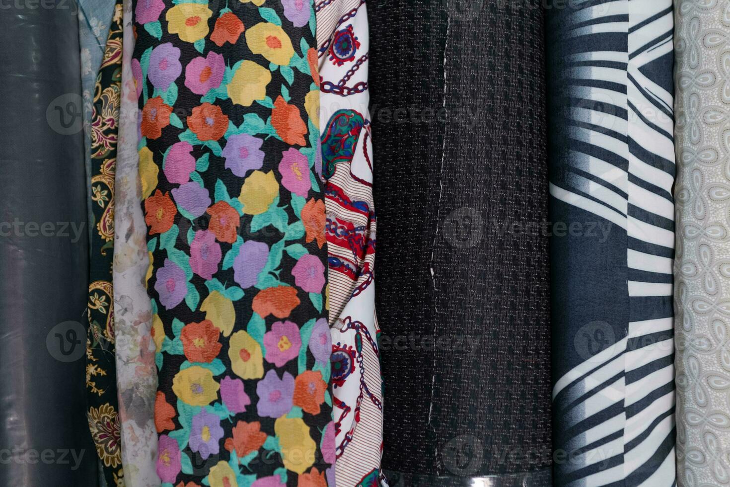 Collection of fashionable fabrics. Samples of different natural fabrics for sewing a fashion collection of clothes. Large selection of fabrics in the store or tailor warehouse. photo