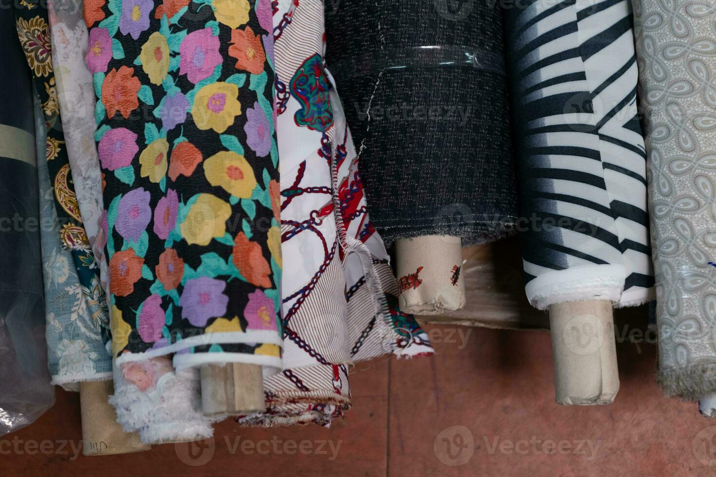 Collection of fashionable fabrics. Samples of different natural fabrics for sewing a fashion collection of clothes. Large selection of fabrics in the store or tailor warehouse. photo