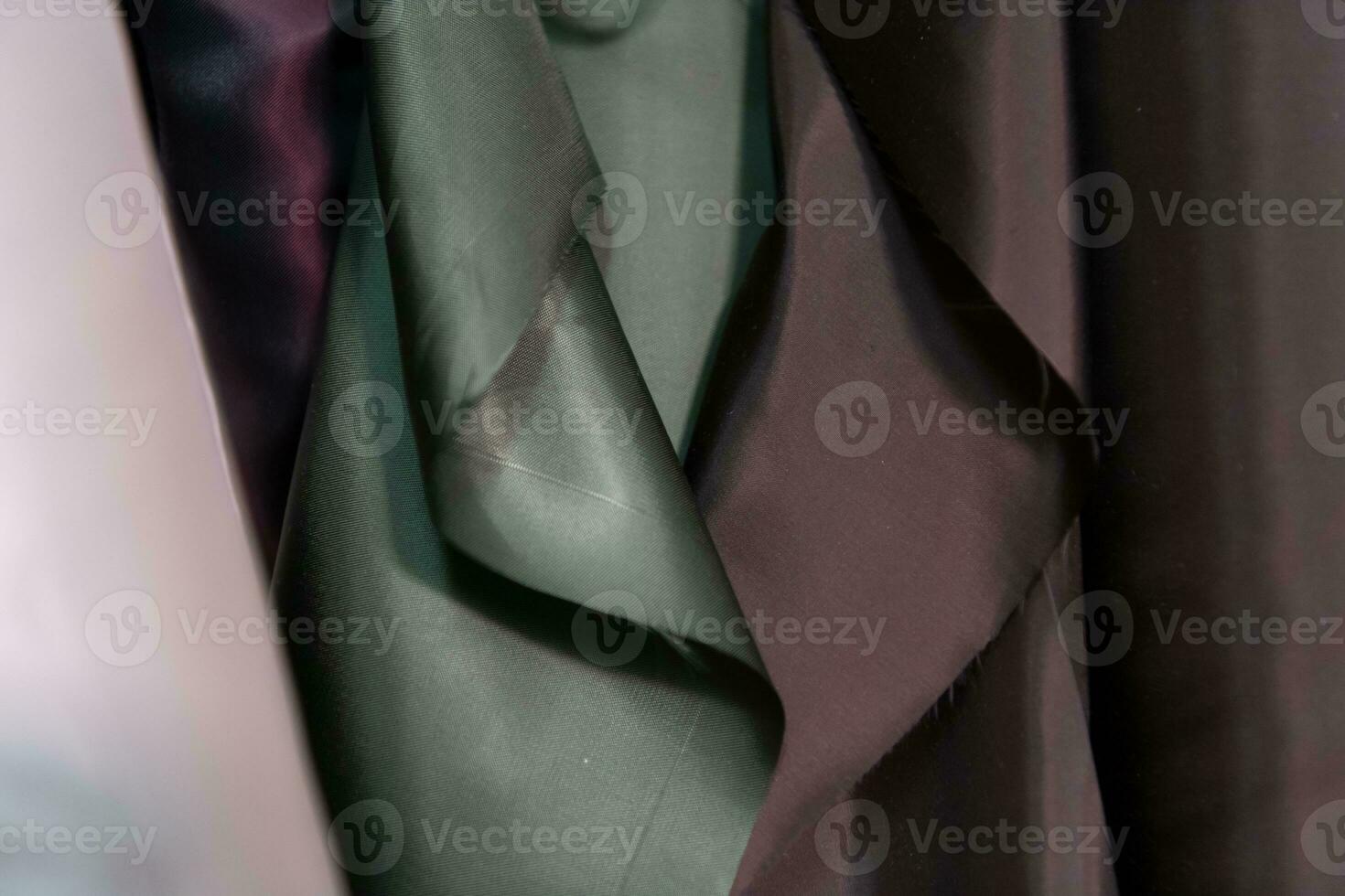 Collection of fashionable fabrics. Samples of different natural fabrics for sewing a fashion collection of clothes. Large selection of fabrics in the store or tailor warehouse. photo