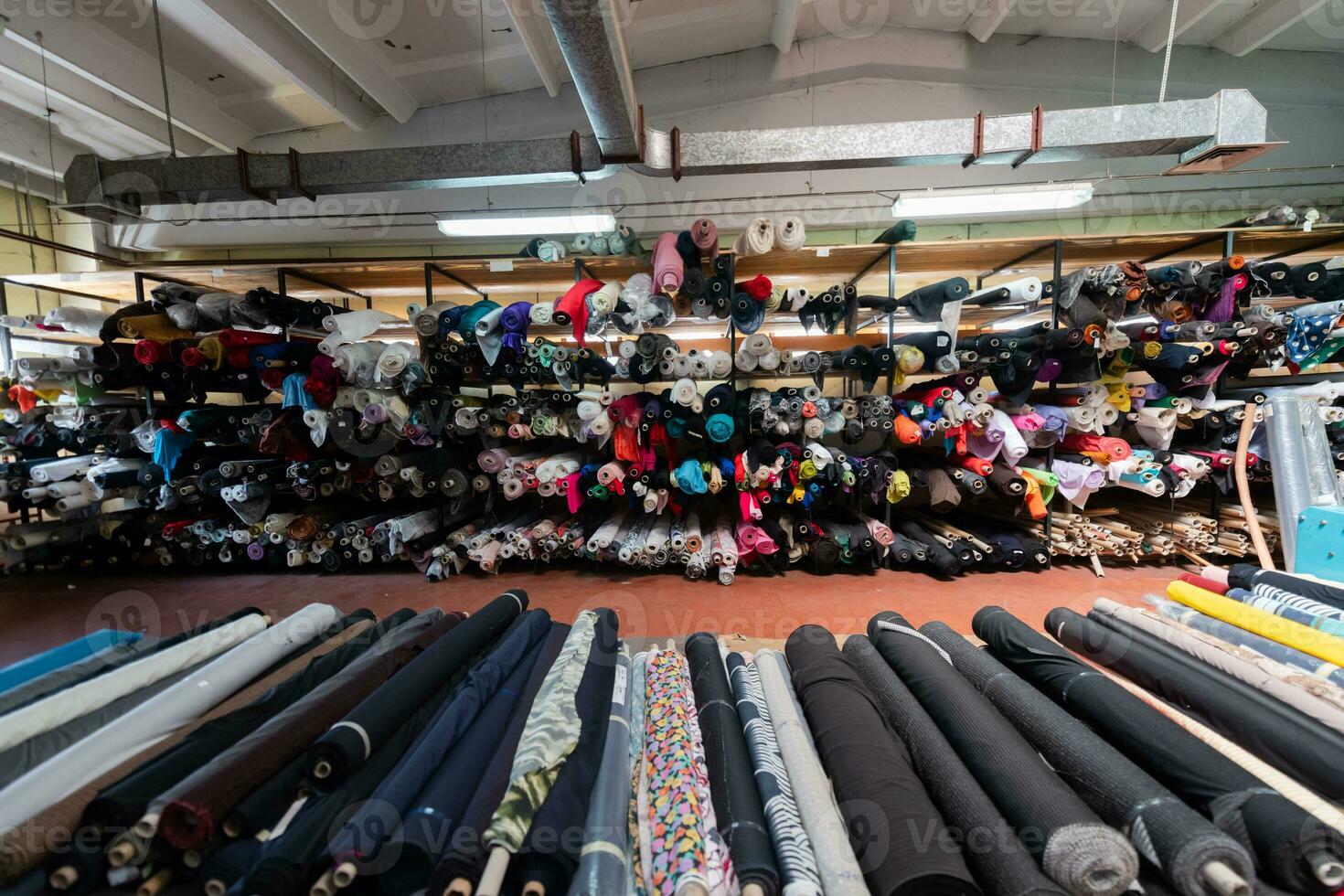 Interior of an industrial warehouse with fabric rolls samples. Small business textile colorful warehouse. photo