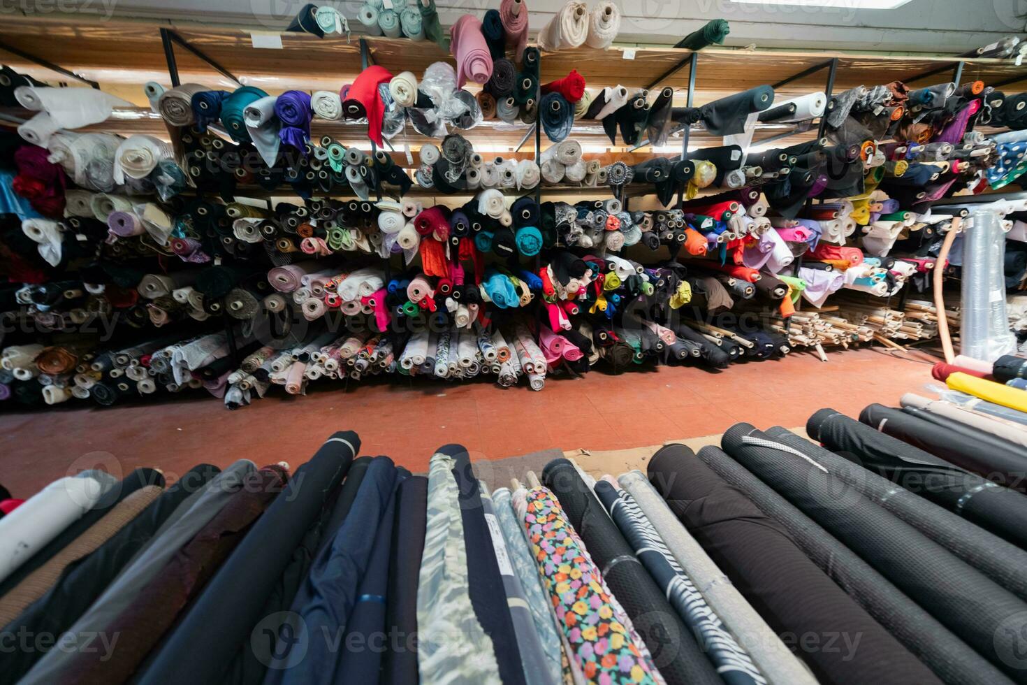 Interior of an industrial warehouse with fabric rolls samples. Small business textile colorful warehouse. photo