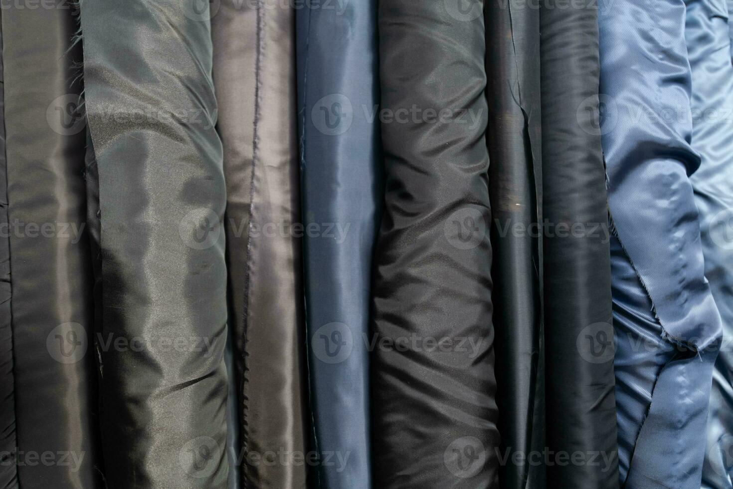 Collection of fashionable fabrics. Samples of different natural fabrics for sewing a fashion collection of clothes. Large selection of fabrics in the store or tailor warehouse. photo