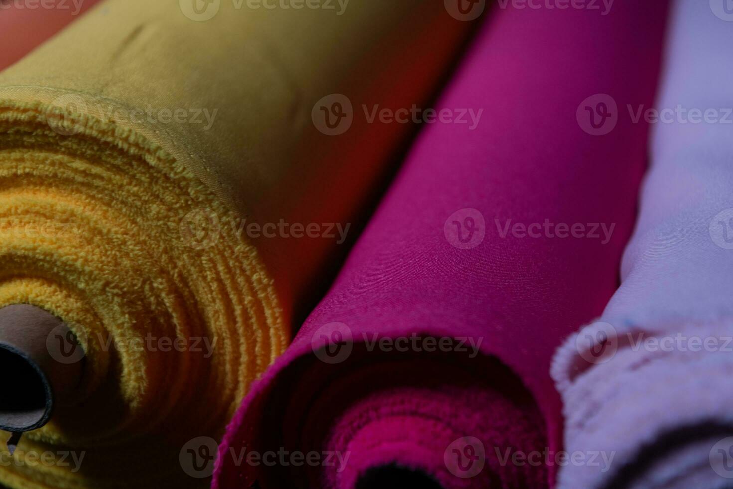 Collection of fashionable fabrics. Samples of different natural fabrics for sewing a fashion collection of clothes. Large selection of fabrics in the store or tailor warehouse. photo