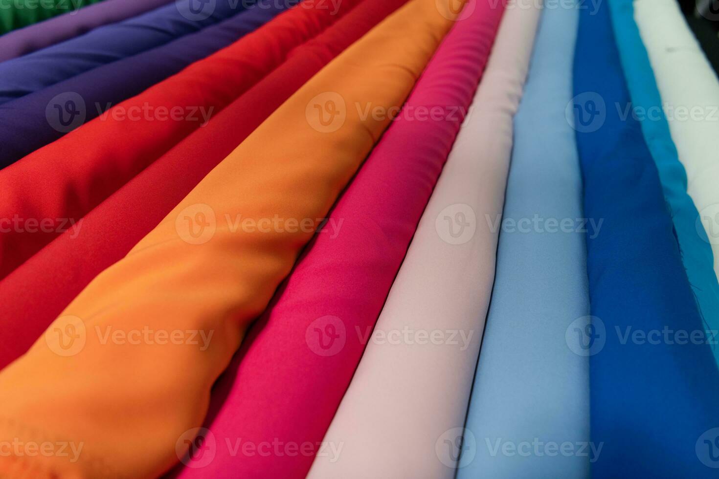 Collection of fashionable fabrics. Samples of different natural fabrics for sewing a fashion collection of clothes. Large selection of fabrics in the store or tailor warehouse. photo