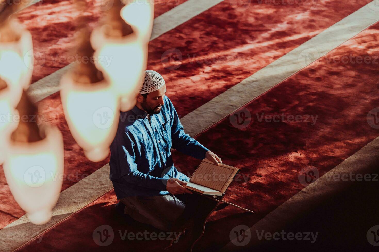 A Muslim reads the holy Islamic book Quraqn in a modern grand mosque during the Muslim holy month of Ranazan photo