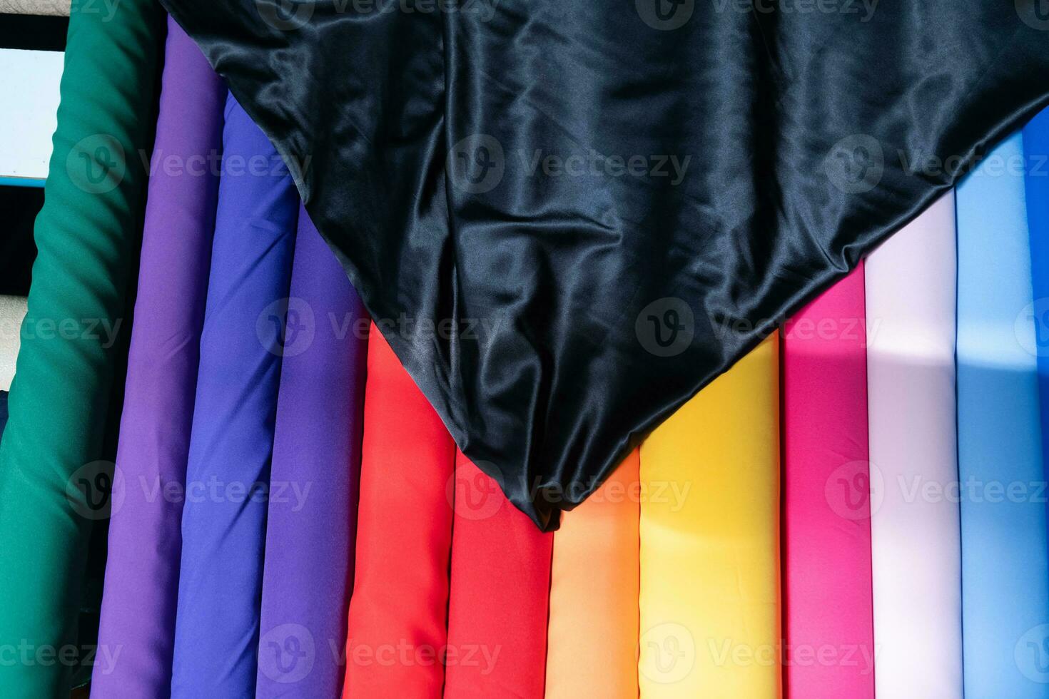 Collection of fashionable fabrics. Samples of different natural fabrics for sewing a fashion collection of clothes. Large selection of fabrics in the store or tailor warehouse. photo