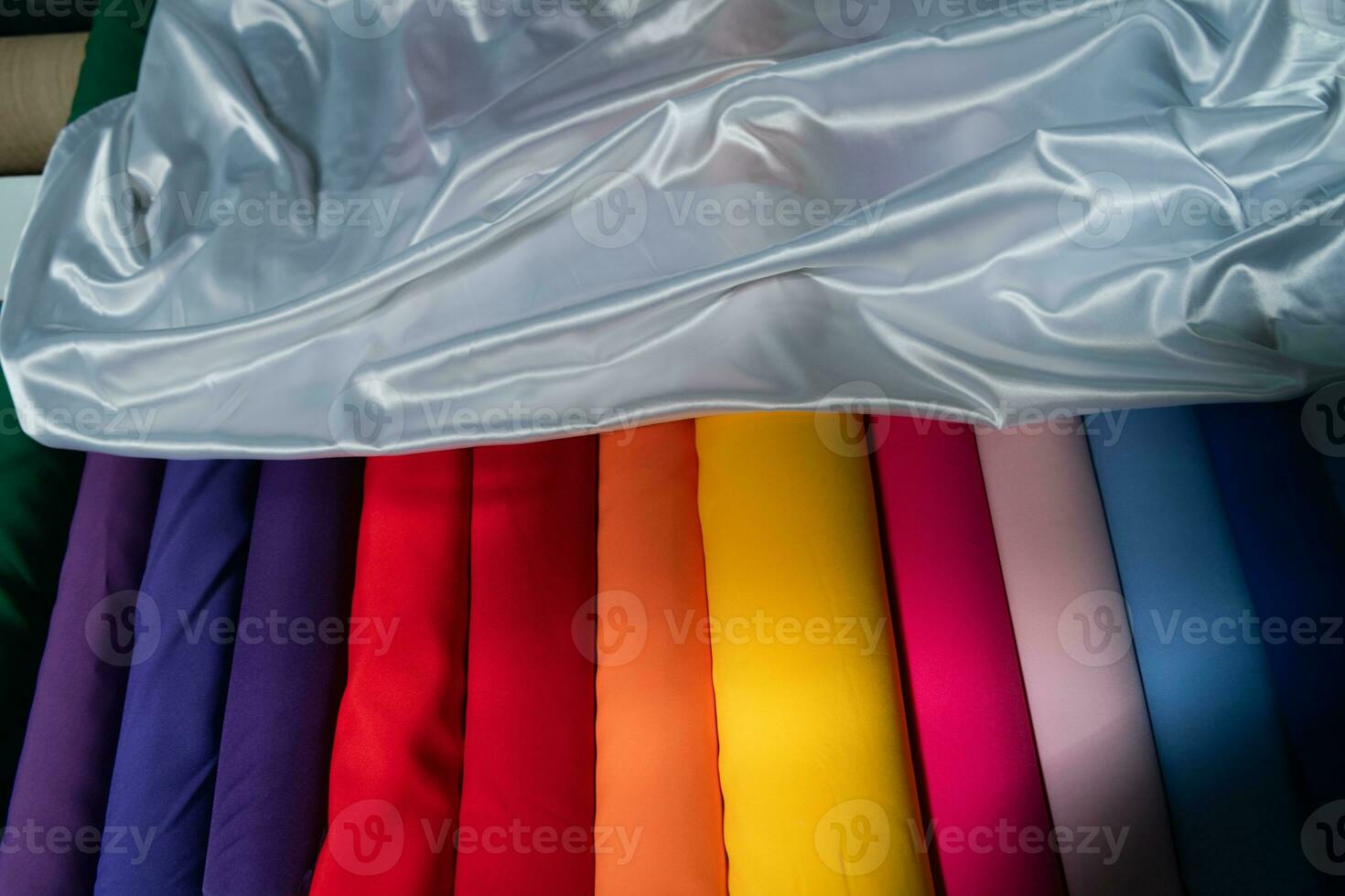Collection of fashionable fabrics. Samples of different natural fabrics for sewing a fashion collection of clothes. Large selection of fabrics in the store or tailor warehouse. photo