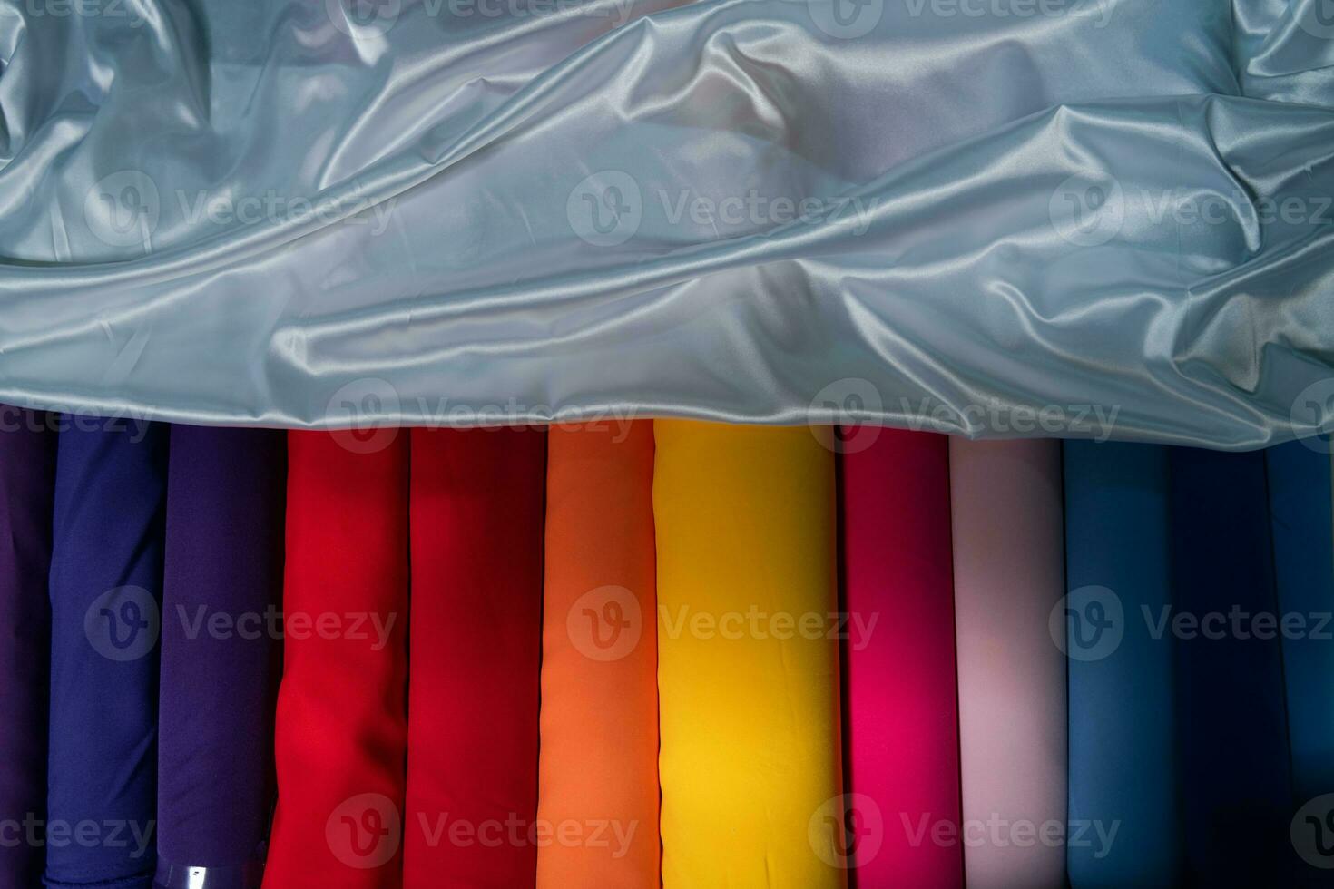 Collection of fashionable fabrics. Samples of different natural fabrics for sewing a fashion collection of clothes. Large selection of fabrics in the store or tailor warehouse. photo