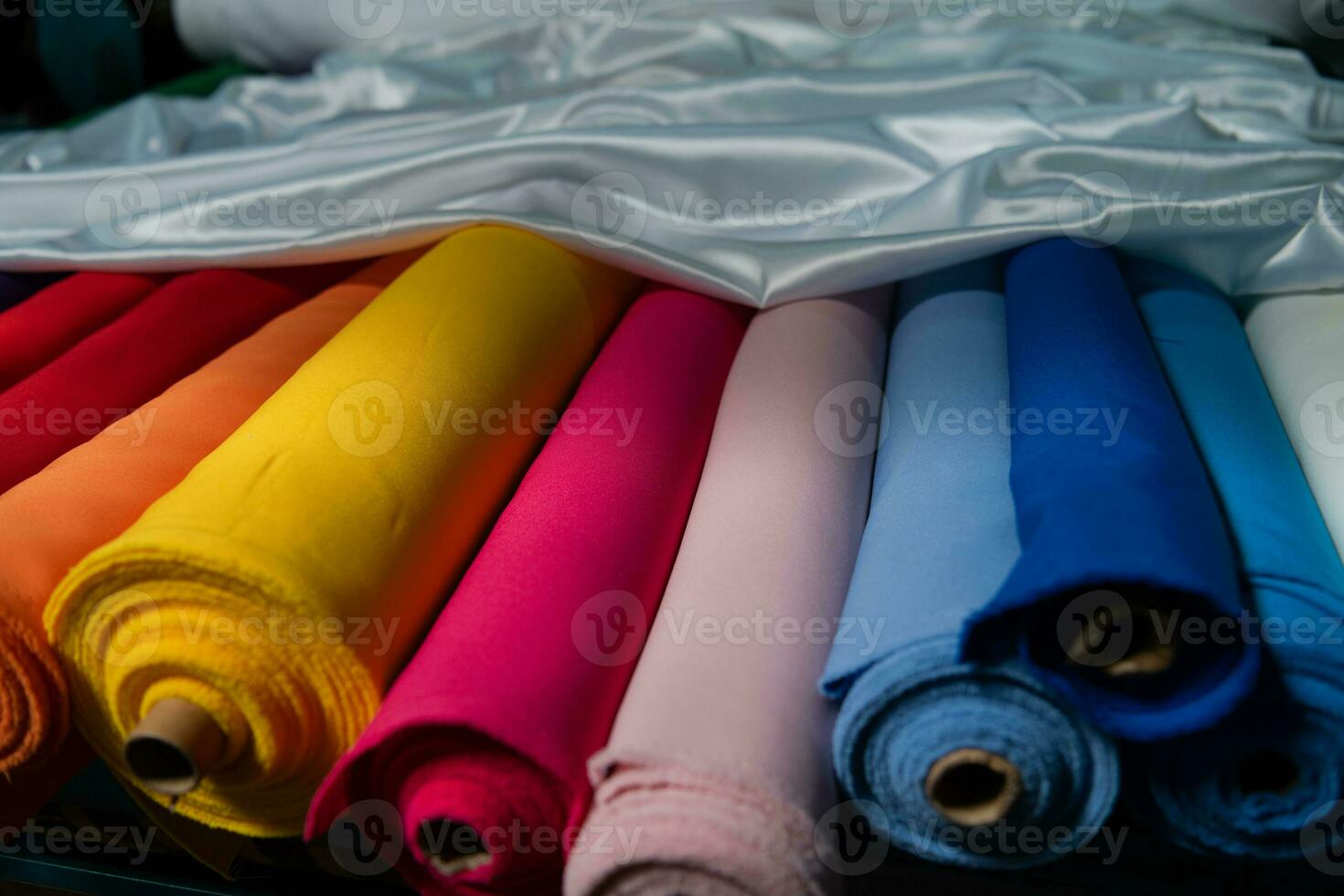 Collection of fashionable fabrics. Samples of different natural fabrics for sewing a fashion collection of clothes. Large selection of fabrics in the store or tailor warehouse. photo