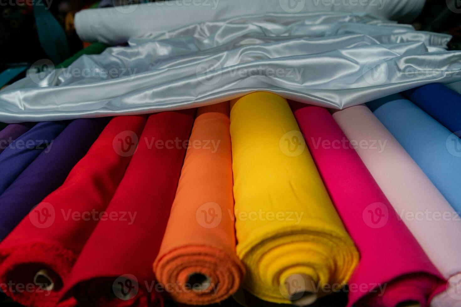 Collection of fashionable fabrics. Samples of different natural fabrics for sewing a fashion collection of clothes. Large selection of fabrics in the store or tailor warehouse. photo