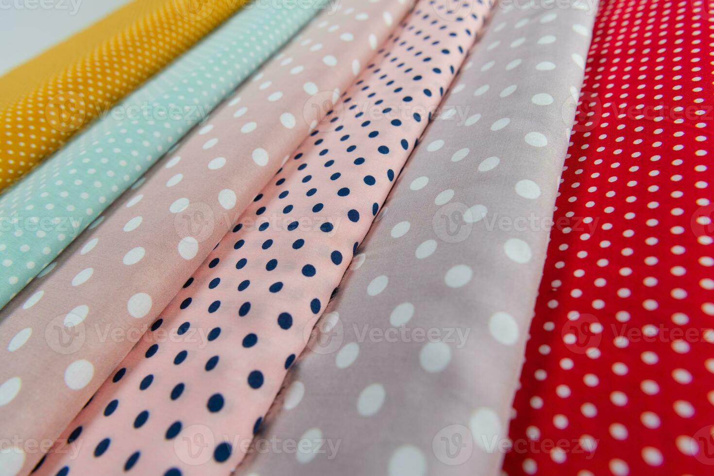 Collection of fashionable fabrics. Samples of different natural fabrics for sewing a fashion collection of clothes. Large selection of fabrics in the store or tailor warehouse. photo