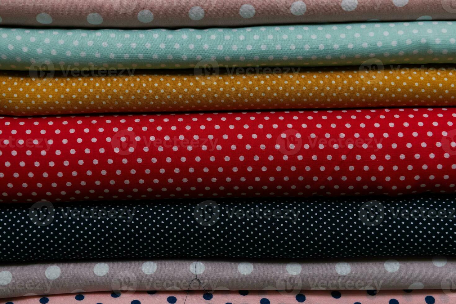 Collection of fashionable fabrics. Samples of different natural fabrics for sewing a fashion collection of clothes. Large selection of fabrics in the store or tailor warehouse. photo