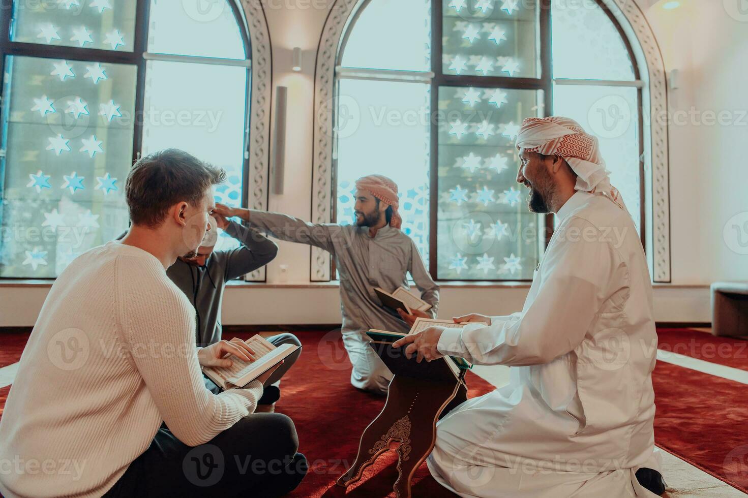 A group of Muslims reading the holy book of the Quran in a modern mosque during the Muslim holiday of Ramadan photo