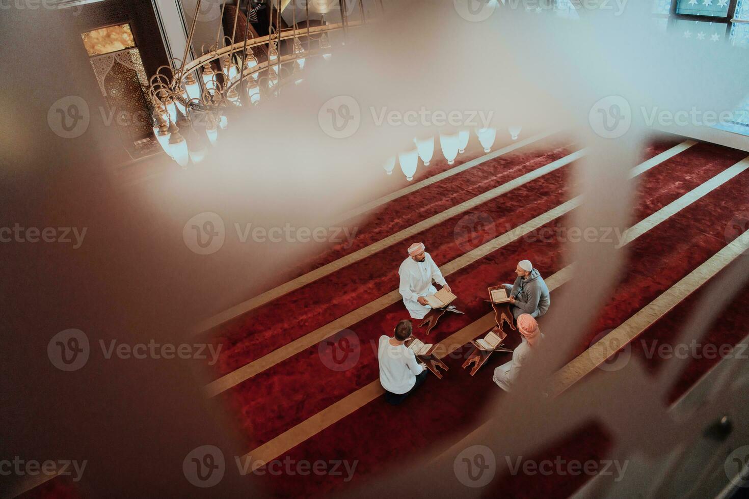 A group of Muslims reading the holy book of the Quran in a modern mosque during the Muslim holiday of Ramadan photo